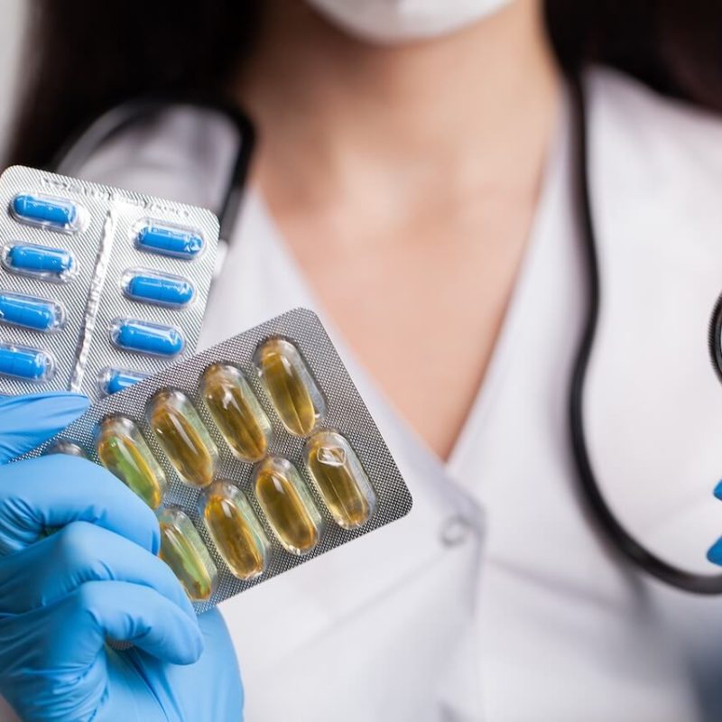 doctor-close-up-holding-white-pills-for-weight-los-2023-12-13-21-17-35-utc